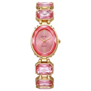 Détail du bracelet doré avec grands cristaux roses et cadran de montre quartz ovale