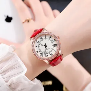 Nahaufnahme einer Damen-Quarzuhr mit rotem Lederarmband und roségoldener Strasslünette