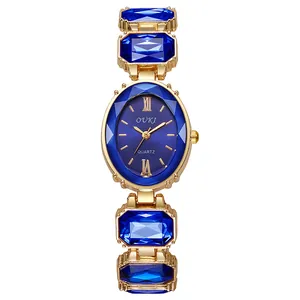Détail d'un bracelet de montre doré orné de grandes pierres de cristal bleu foncé