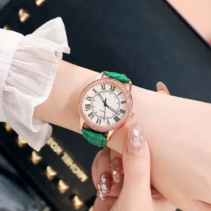 Detail einer Damen-Quarzuhr mit smaragdgrünem Lederarmband und Strassstein-Lünette