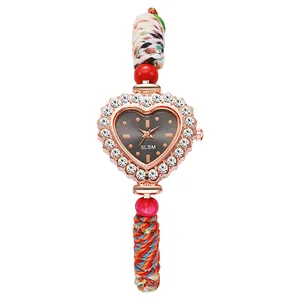 Detail of heart-shaped watch with crystal bezel and colorful braided woven strap