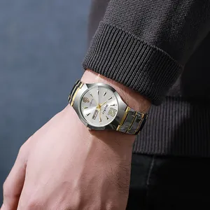 Detalle del reloj bicolor de acero oro y plata con índices de diamante y ventana de fecha