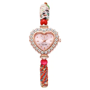 Detail of heart-shaped quartz watch with rhinestone bezel and colorful woven strap