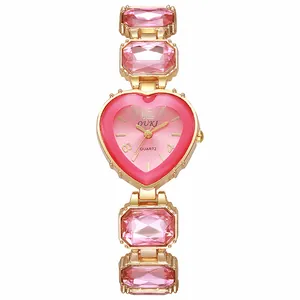 Dettaglio dell'orologio al quarzo a forma di cuore con cristalli rosa e cinturino oro