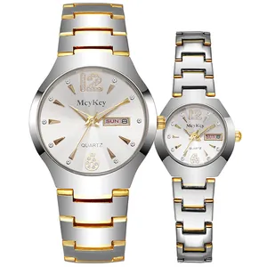 Detalle de relojes de pareja en acero inoxidable plateado y dorado con calendario