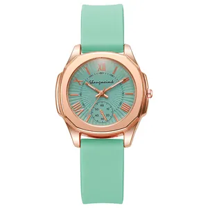 Detail of rose gold octagonal watch case with mint green dial and silicone strap
