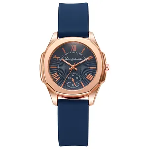 Detail of rose gold case with navy blue silicone strap and radial pattern dial