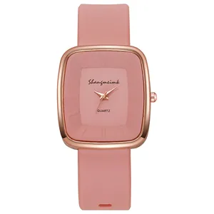 Close-up of pink silicone watch strap and rose gold square dial with quartz movement