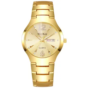 Detalle de reloj de cuarzo dorado que muestra la función de calendario e índices de cristal
