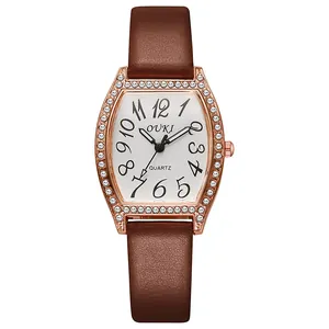 Detail van roségouden tonneau horloge met kristallen lunette en bruine lederen band