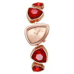 Detail einer roségoldenen Schmuckuhr mit rotem Kristallarmband und dreieckigem Zifferblatt