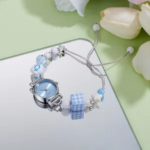 Detail of beaded bracelet watch with blue smiley face and silver quartz dial