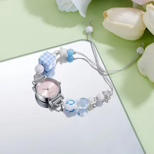 Detail of quartz wristwatch featuring pink dial and colorful bead charm bracelet strap
