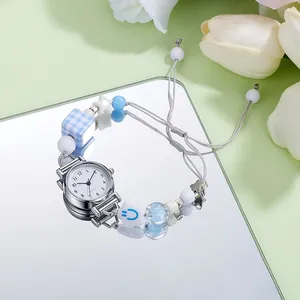 Detail of creative pearl bracelet watch with blue beads and mirror base reflection