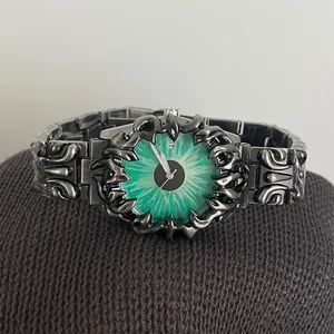 Détail de la montre gothique à quartz avec cadran œil de démon vert et bracelet métal