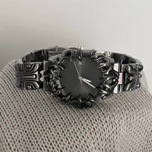 Détail macro d'une montre gothique en métal avec lunette épine et guichet de date