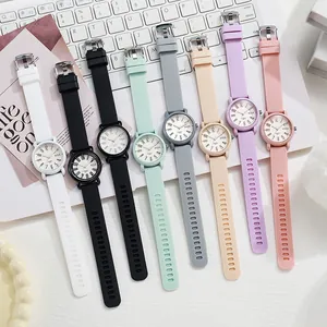 Eight minimalist quartz watches with colorful silicone straps on a white laptop keyboard