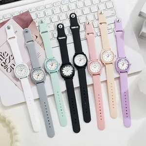 Relojes de cuarzo minimalistas en siete colores pastel sobre el teclado de un portátil