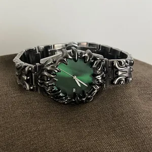 Détail macro d'une montre gothique en métal avec cadran vert dégradé et dateur