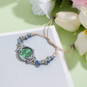 Dettaglio dell'orologio con perline, quadrante verde smeraldo e cinturino intrecciato