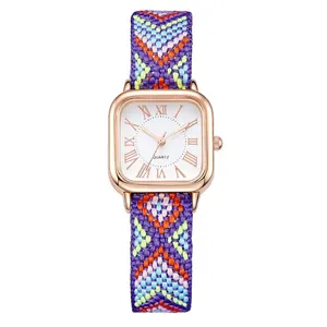 Detail view of woven purple strap and rose gold square quartz watch with Roman numerals