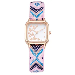 Détail du boîtier de montre carré en or rose avec papillons et bracelet tissé