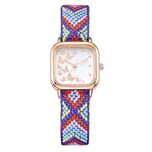 Détail de la montre carrée or rose avec cadran papillon et bracelet tissé coloré