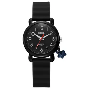 Detail of black quartz watch with white numerals and a blue star pendant charm