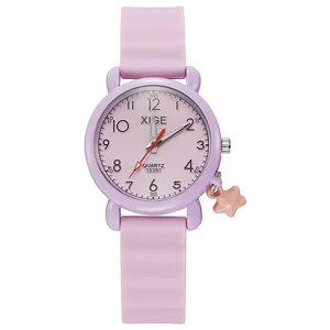 Detail of pink quartz watch with silicone strap and a cute star-shaped pendant charm
