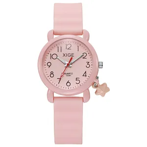 Detailed view of pink quartz watch with silicone strap and star pendant decoration