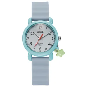 Detail of child quartz watch with light blue case, star pendant and red second hand