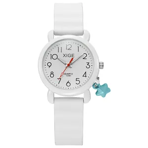 Detail view of white silicone quartz watch with red second hand and blue star charm