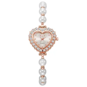 Detalle del reloj de cuarzo en forma de corazón oro rosa con diamantes y correa de perlas