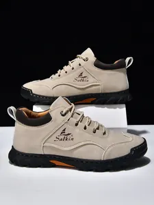 Detail von beigen Outdoor-Freizeitschuhen mit Nähten, Salkin-Logo und dicker Gummisohle