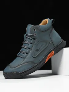Detail of blue suede leather boot featuring handcrafted stitching and LDECK logo embossment