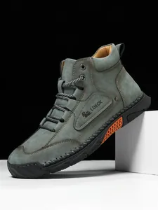 Detail of high-top leather boot featuring orange honeycomb sole inserts and stitching