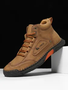 Detail of premium brown suede leather boots with contrast stitching and non-slip rubber soles