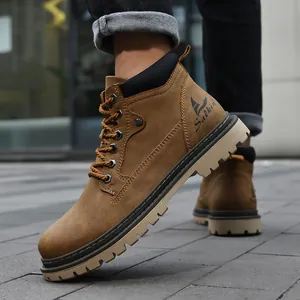 Close-up of brown suede men's high-top work boots with metallic eyelets on city street