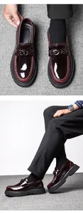 Detailed macro view of burgundy patent leather loafers with metallic chain and thick sole