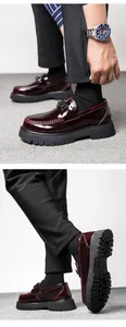 Macro view of burgundy patent leather loafers with thick soles and metal buckle detail