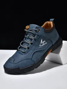 Nahaufnahme dunkelblauer Leder-Loafer mit orangefarbenem Futter und robuster Gummisohle