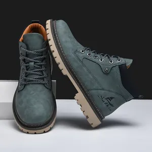 Detailed view of teal mid-top work boots with thick rubber soles and metal eyelets