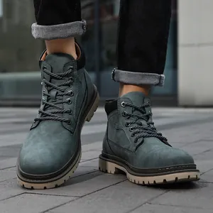 Detail of men's high-top work boots featuring gray-green leather and durable rubber soles