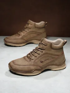 Détail de bottes en cuir marron avec logo LDECK surpiqué et semelle antidérapante