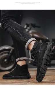 Detail view of black high-top leather boots with contrast stitching and thick rubber soles