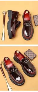 Close-up of wine red patent leather loafers with silver chain and thick black rubber sole