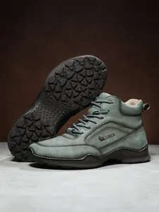 Gros plan sur des bottes en cuir PU vert olive avec semelles en caoutchouc robustes