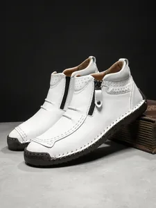 Detail of white leather boots featuring side zipper and hand-stitched craftsmanship