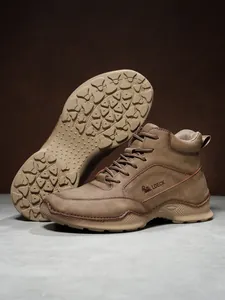 Détails de bottines homme en similicuir marron avec coutures à la main et logo gravé