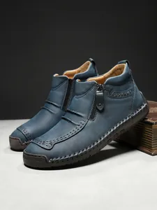 Detail of blue leather men boots with manual stitching and functional side zipper